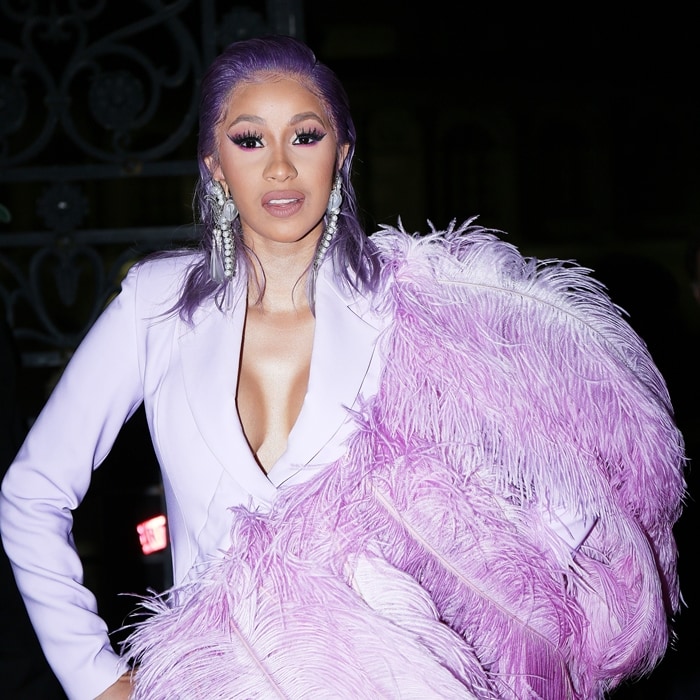 Cardi B stuns in a dramatic lavender feathered outfit, making a bold statement with her matching purple hair and striking accessories