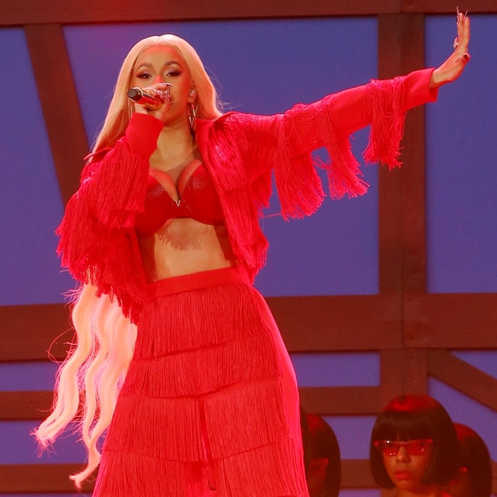 Cardi B commands the stage in an all-red fringed ensemble, delivering an electrifying performance with her signature bold style and energy
