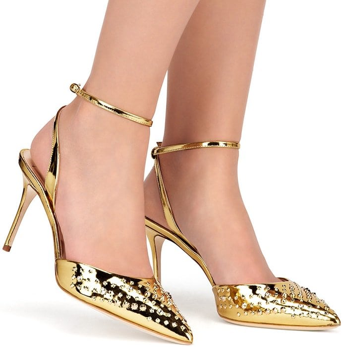 The mirrored golden leather is studded across the pointed toes, with low-slung uppers and a heel-fastening strap creating a streamlined silhouette