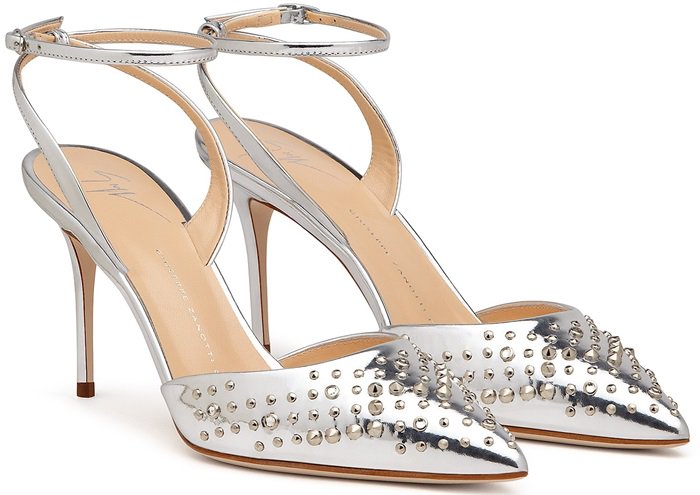 The mirrored silver leather is studded across the pointed toes, with low-slung uppers and a heel-fastening strap creating a streamlined silhouette
