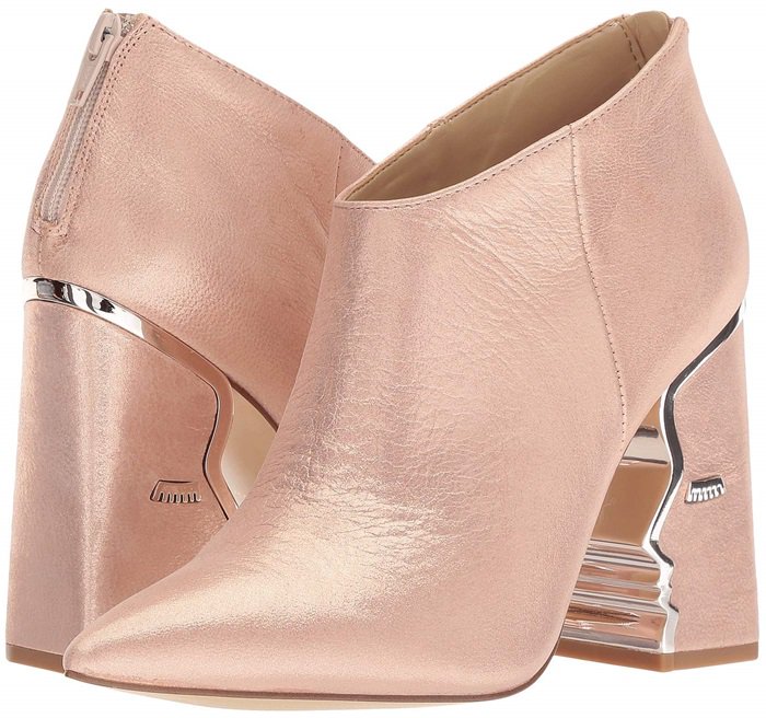 Heeled ankle boots with suede upper featuring face silhouette and hardware detailing