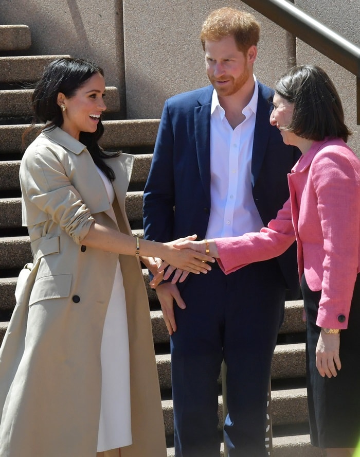 Meghan Markle styled her white dress with a trench coat by Australian designer Martin Grant