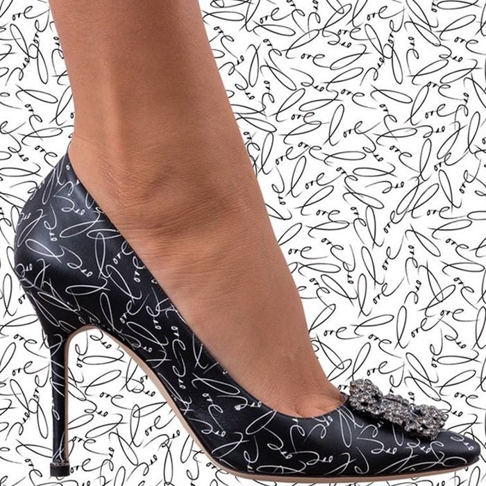 These black smooth calfskin pumps are debossed at the sole with "A decade of love" lettering and printed with a white "Love" motif