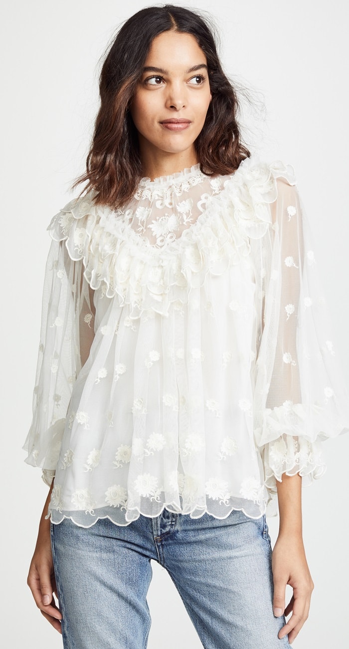 An ethereal tulle blouse decorated with embroidered blooms and frothy ruffles adds wispy romance to your day.