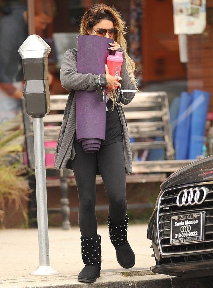 Vanessa Hudgens walks out in yoga pants while hiding behind her yoga mat