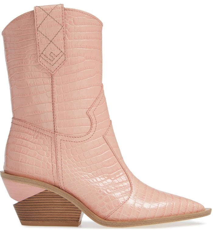 The pink of the millennium colors a section of a notched stacked heel and all of the glossy croc-embossed leather of updated Western boots with a sharp toe