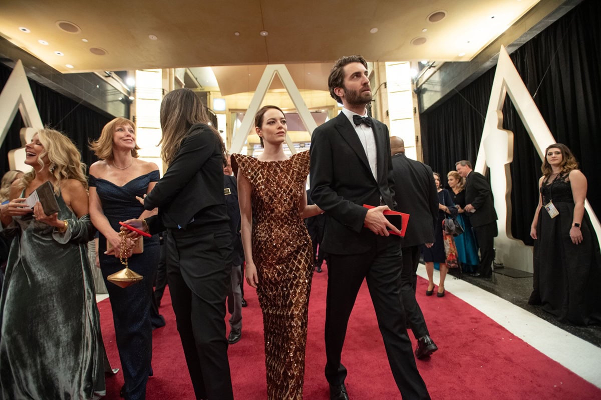 Emma Stone walks the Oscars red carpet arm-in-arm with her boyfriend Dave McCary, turning heads in her striking beehive-inspired Louis Vuitton gown