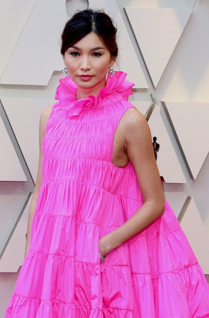 Gemma Chan's brunette hair was styled by Clariss Rubenstein into a disheveled bun at the nape of her neck