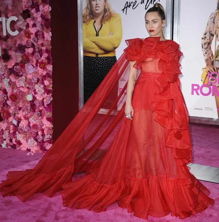 Miley Cyrus in a red Valentino with crimson ruffles and a sweeping cape
