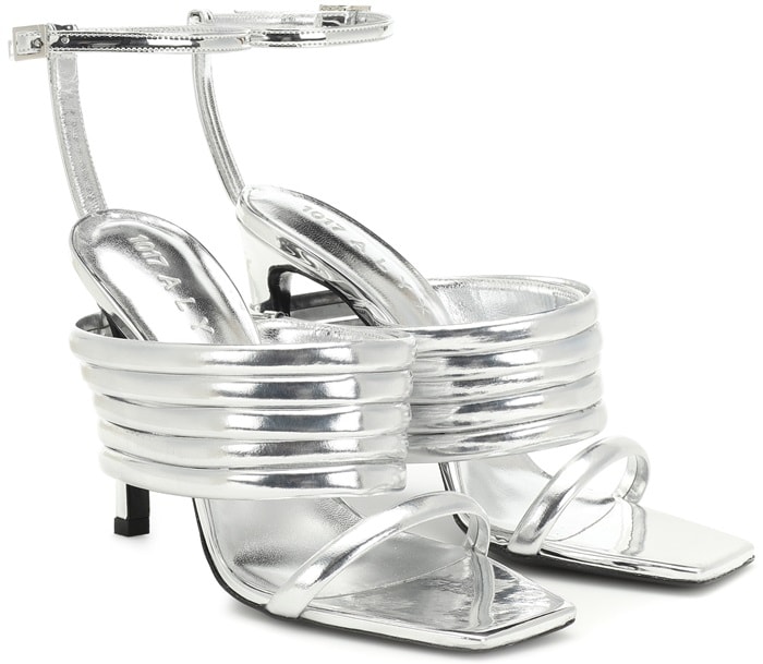 These high-shine metallic silver leather sandals are set on a high coated heel and have a square-toed silhouette, while the thick ridged strap gives them their unique look