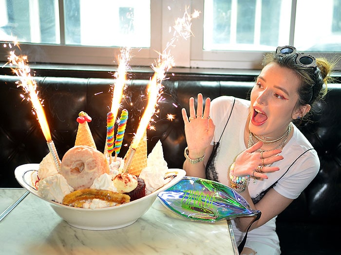 Bella Thorne taking in her ice cream, donut, and cupcake sundae topped with sparklers