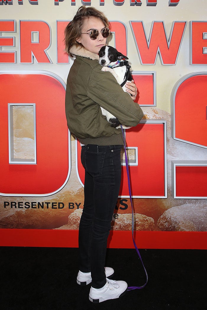 Cara Delevingne bonding with the dogs at Imax's "Superpower Dogs" World Premiere at the IMAX – California Science Center in Los Angeles, California, on March 9, 2019