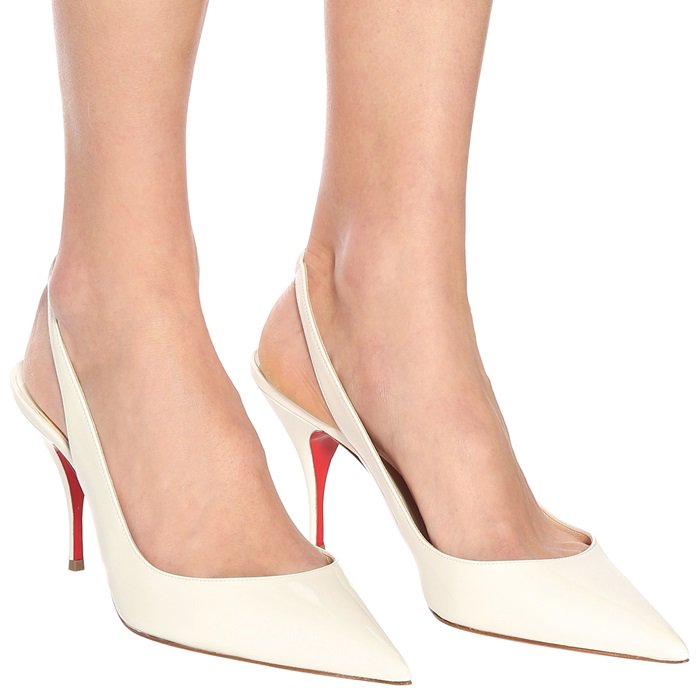 The Clare Sling pointy-toe pump is covered in white patent leather and adjusts with an elastic slingback strap on an 80mm stiletto heel