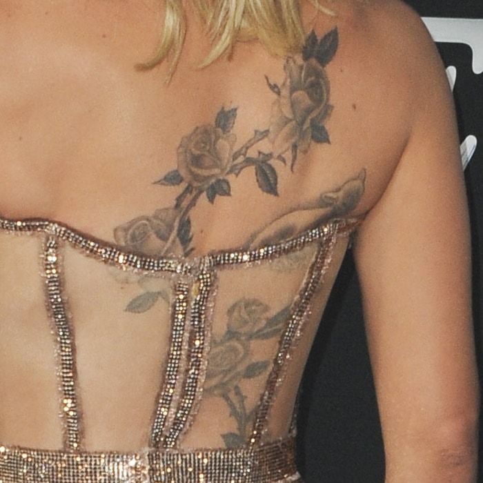 Scarlett Johansson's back tattoo could be inspired by her daughter, Rose Dorothy Dauriac, and features a variety of flowers, including roses, lilies, and daisies, as well as a lamb