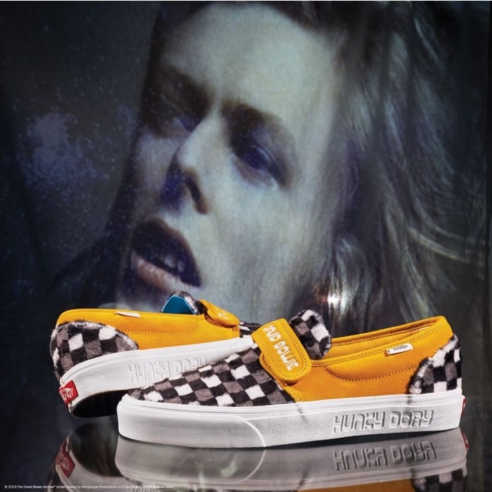 This slip-on style combines the iconic low profile silhouette with sturdy textile and suede uppers, a hook-and-loop closure, the signature Vans checkerboard print, and custom Bowie details