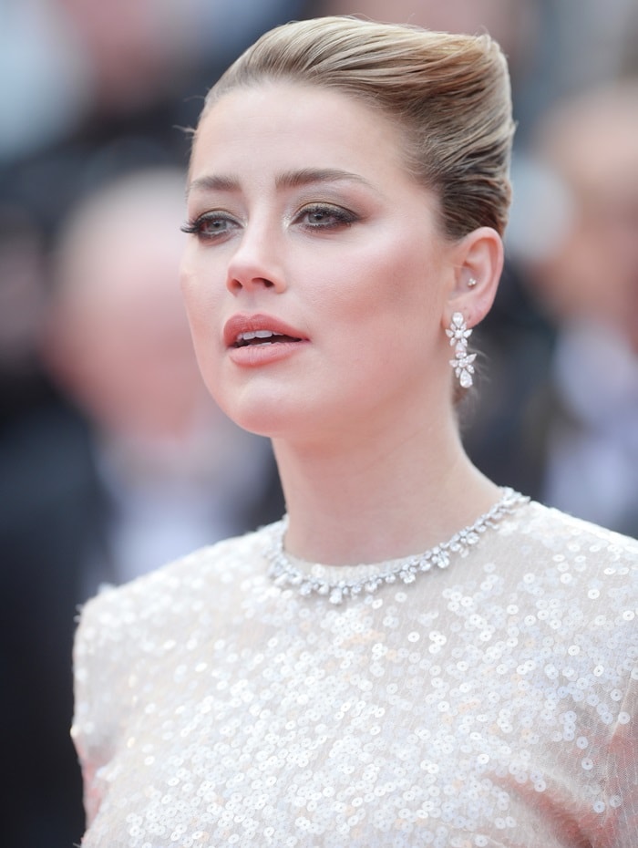 Amber Heard completes her glamorous Cannes look with a sleek updo and dazzling floral Chopard earrings