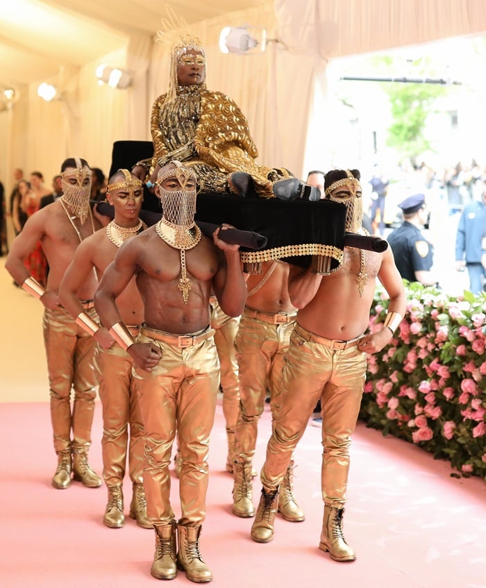 Dressed as an Egyptian pharaoh, Billy Porter is carried by six shirtless men