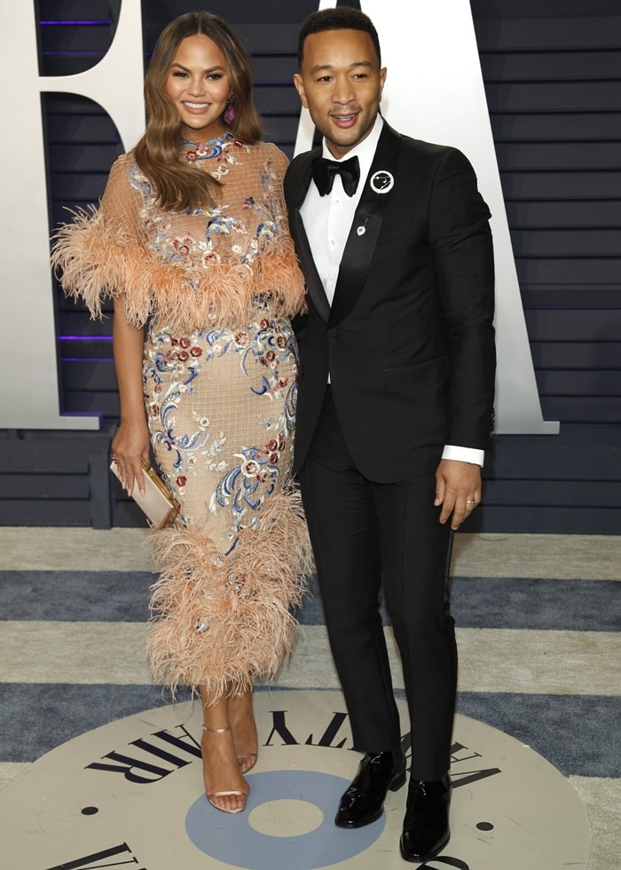 Chrissy Teigen and her husband John Legend pose together as they arrive at the 2019 Vanity Fair Oscar Party