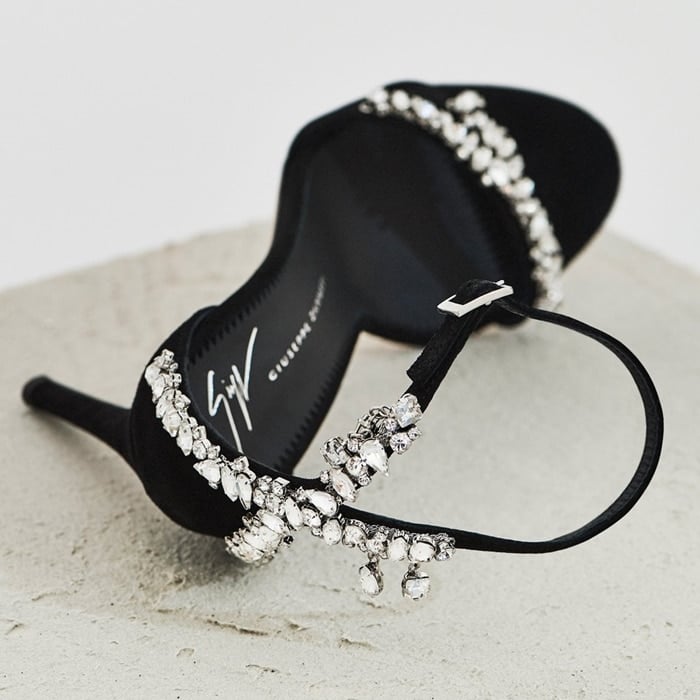 Black suede Lynette sandals fasten with an ankle strap and are adorned with sparkling rhinestones