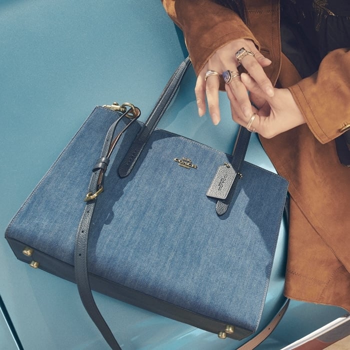 The denim Charlie Carryall from COACH is a versatile bag that combines uptown style with downtown cool