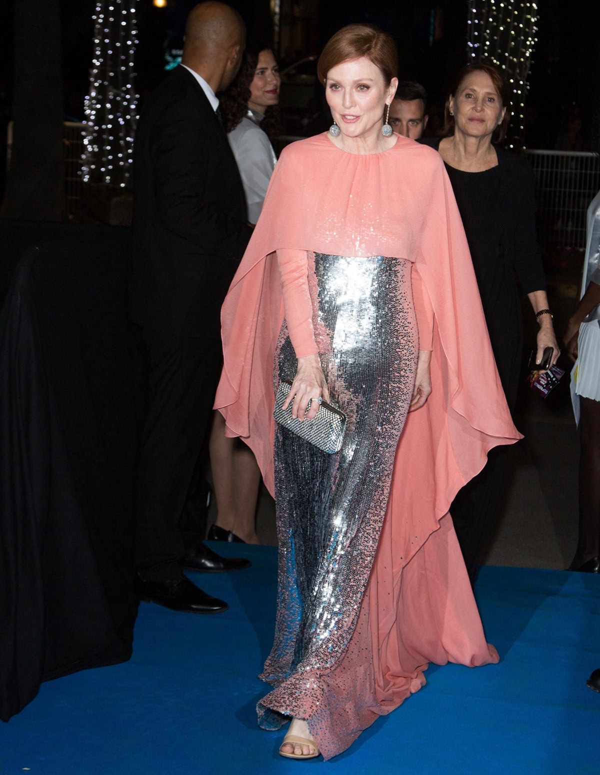 Julianne Moore made a dramatic entrance at the 2019 Cannes Rocketman premiere in a silver sequined Givenchy Haute Couture column gown layered with a flowing coral silk cape and finished with delicate nude sandals that softened the bold, theatrical silhouette