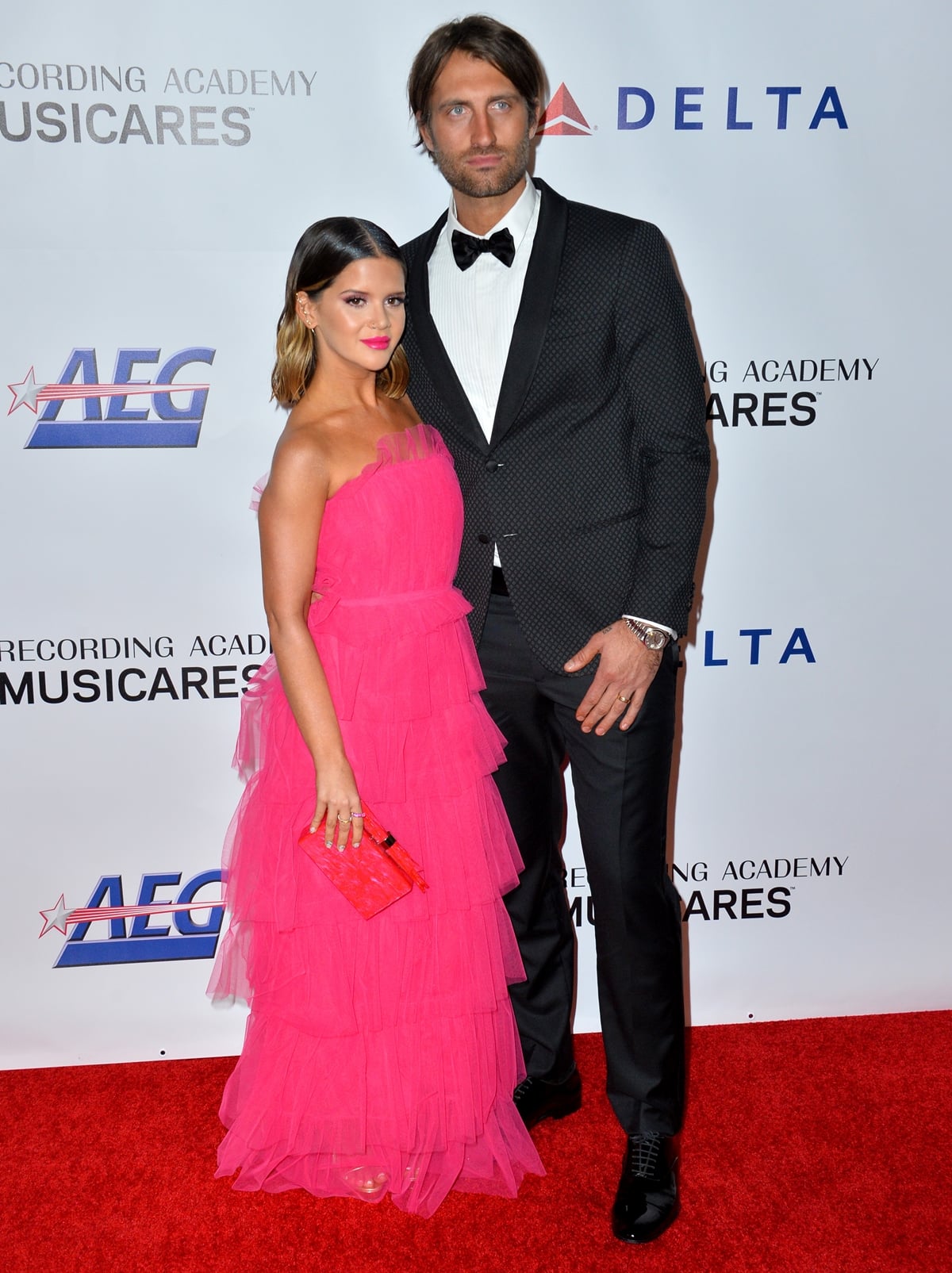 Maren Morris in a pink Carolina Herrera dress with an Edie Parker clutch, and jewelry by Luisa Alexander, KatKim, and Beladora with her husband Ryan James Hurd on the red carpet at the 2019 MusiCares Person of the Year gala