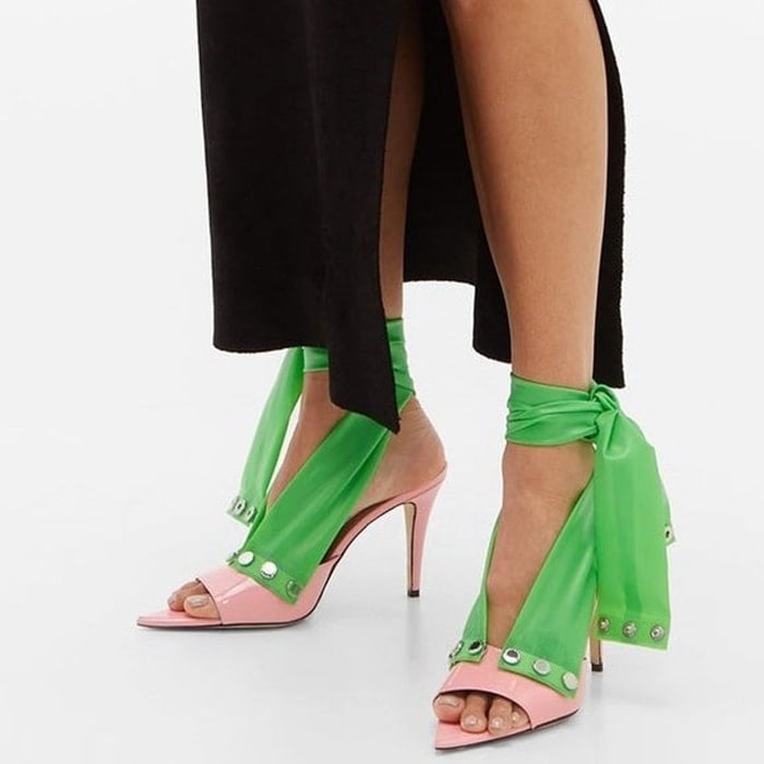 Crafted in Italy, these pink mules from Christopher Kane are comprised of exaggerated green ankle straps that are set with engraved silver-tone metal buttons, then set on a high stiletto heel