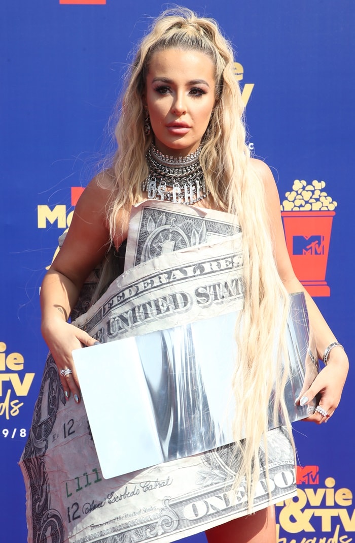 Tana Mongeau's trashy dollar bill dress featuring a huge silver money clip belt