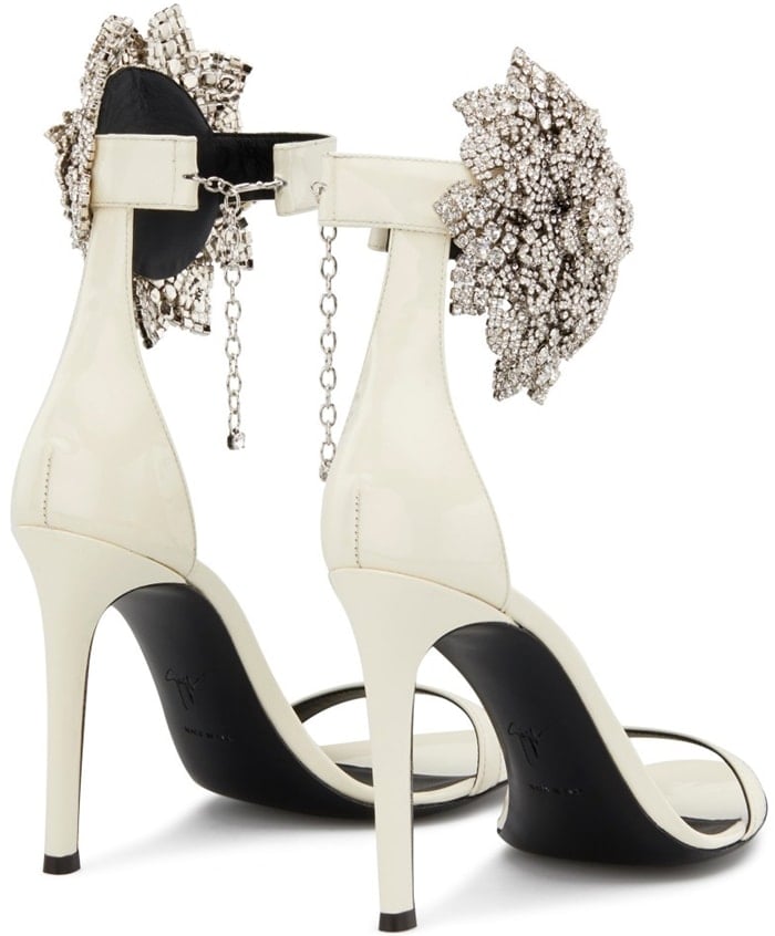 These high-heel, white patent leather sandals are characterized by the crystal flower accessory on the side