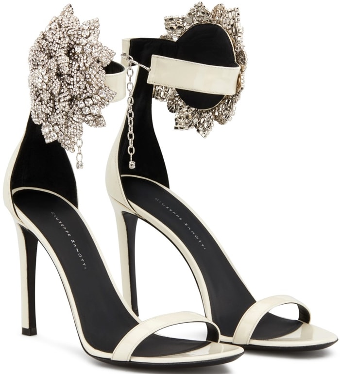 These high-heel, white patent leather sandals are characterized by the crystal flower accessory on the side