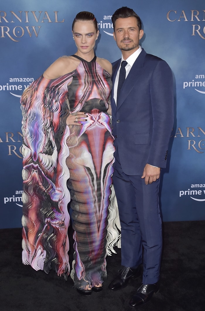 Cara Delevingne strikes a pose on the black carpet with her co-star Orlando Bloom at the premiere of Carnival Row