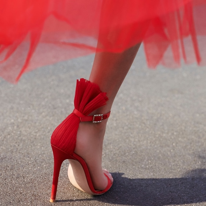 Gianvito Rossi’s red Belvedere sandals feature a plissé tulle panel that fans out above the cuff strap – an element which encapsulates the label’s experimental silhouettes