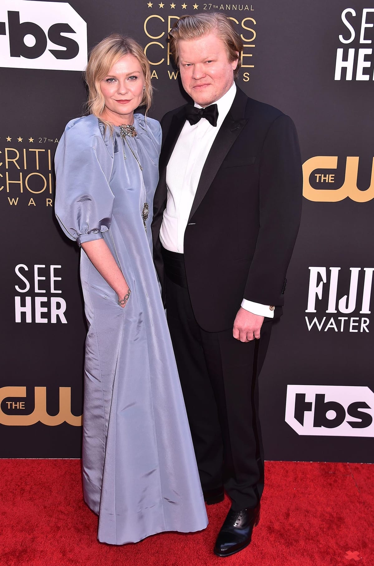 Jesse Plemons in a Giorgio Armani Made to Measure tuxedo and Santoni shoes and Kirsten Dunst in a silver-blue Julie de Libran Couture dress with bishop sleeves, Roger Vivier shoes, and Fred Leighton jewelry
