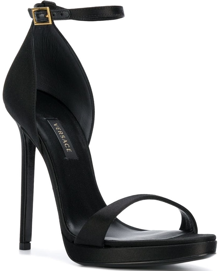 Crafted in Italy, these black leather open toe pumps from Versace feature an open toe, a branded insole, an ankle strap with a side buckle fastening and a high heel