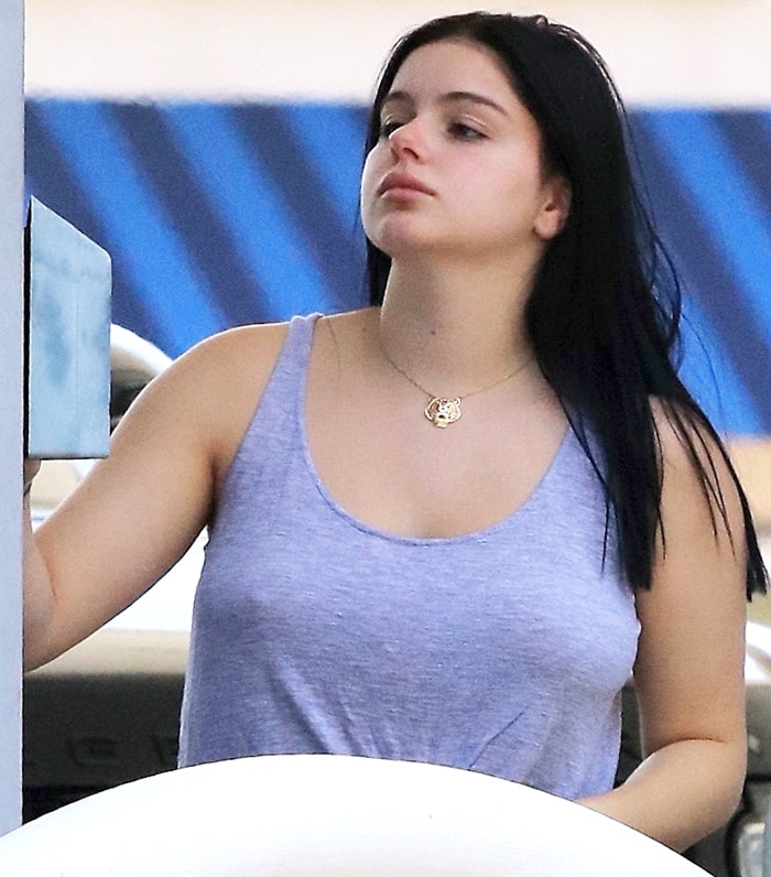 Ariel Winter in a grey sleeveless t-shirt while pumping gas for her white Range Rover