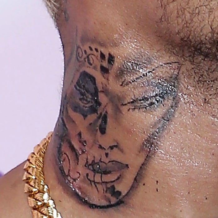 Chris Brown's sugar skull neck tattoo associated with the Mexican celebration of the Day of the Dead