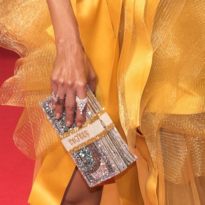 Jennifer Lopez toted a Judith Leiber Couture hard clutch bag in stacked money silhouette