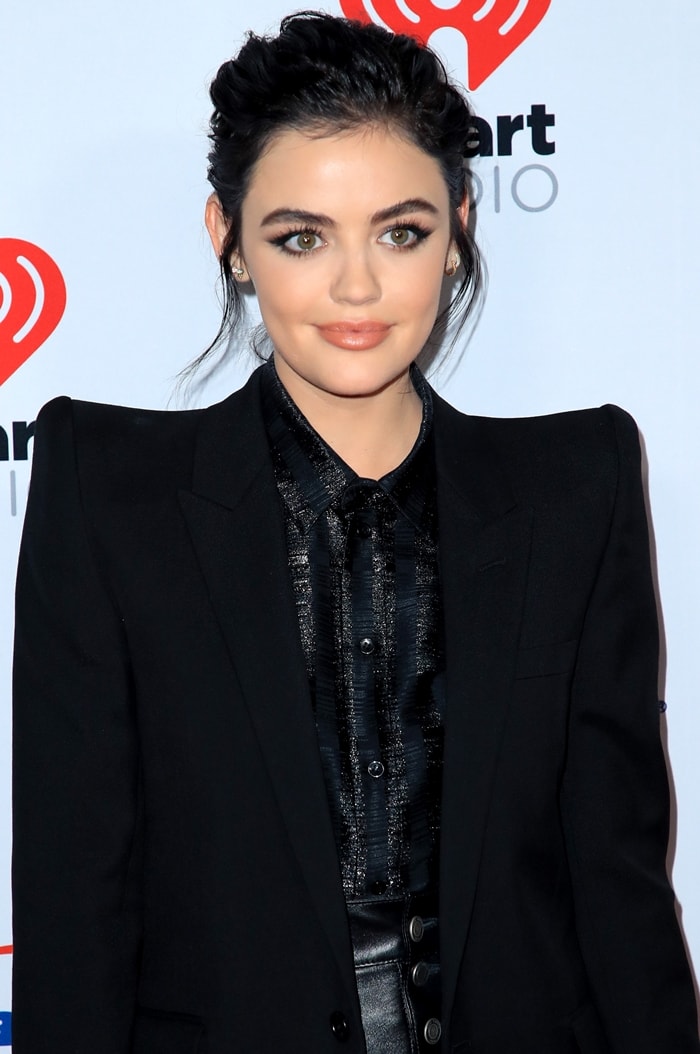 Lucy Hale stuns in a sleek black ensemble featuring a metallic striped blouse, a structured blazer, and leather high-rise shorts