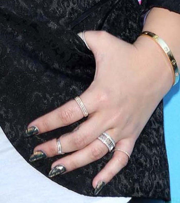 Demi has the script "Peace" tattooed on her middle finger