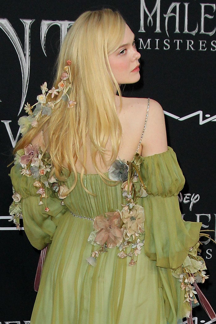 Elle Fanning with flowers in her blonde hair and Gucci gown