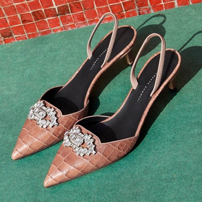 These high-heel, alligator print pumps are characterized by their vintage pink colour, and embellished by a crystal accessory on the front