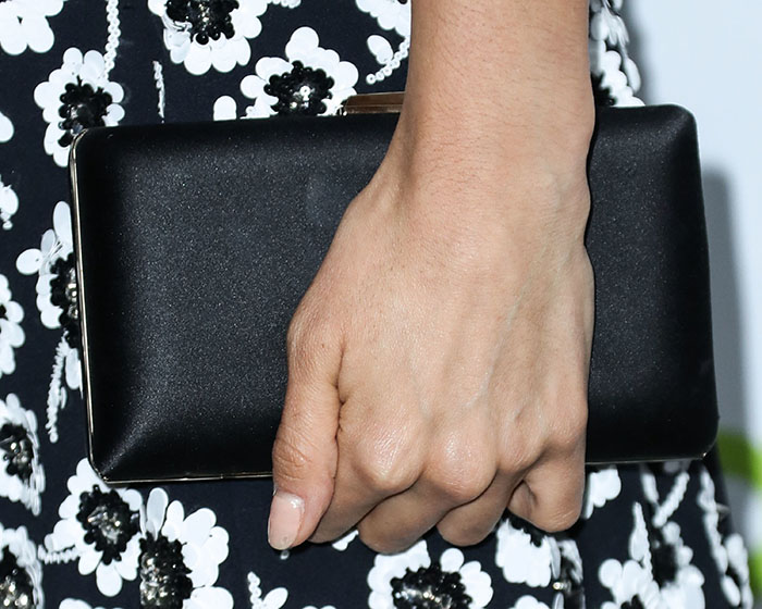 Nina Dobrev accessorized her floral ensemble with the sleek black suede Jimmy Choo ‘Clemmie’ clutch