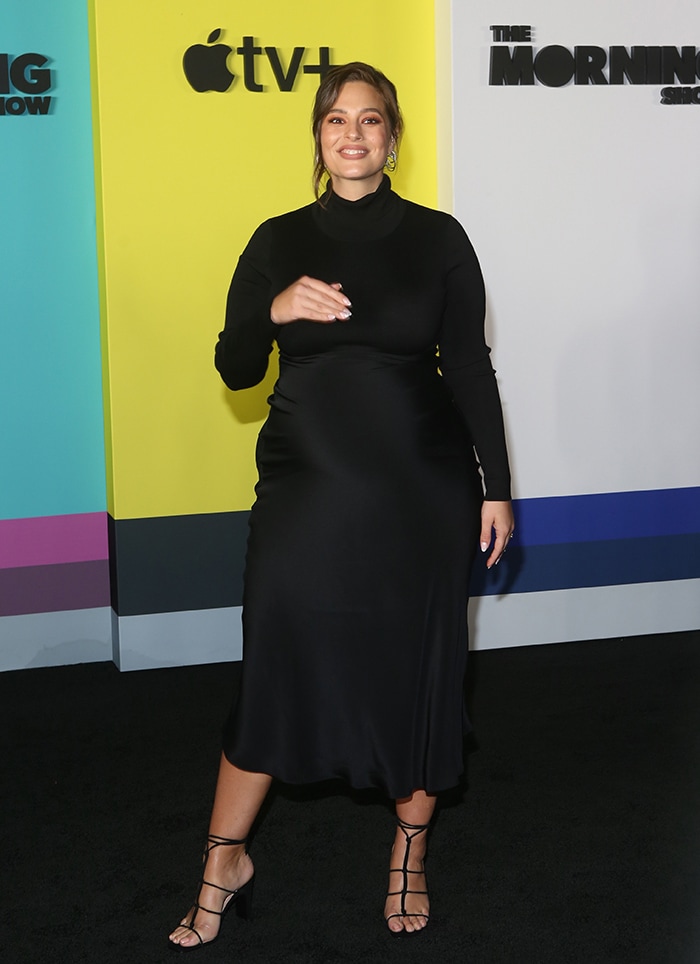 Ashley Graham shows off her growing baby bump in a TSE dress