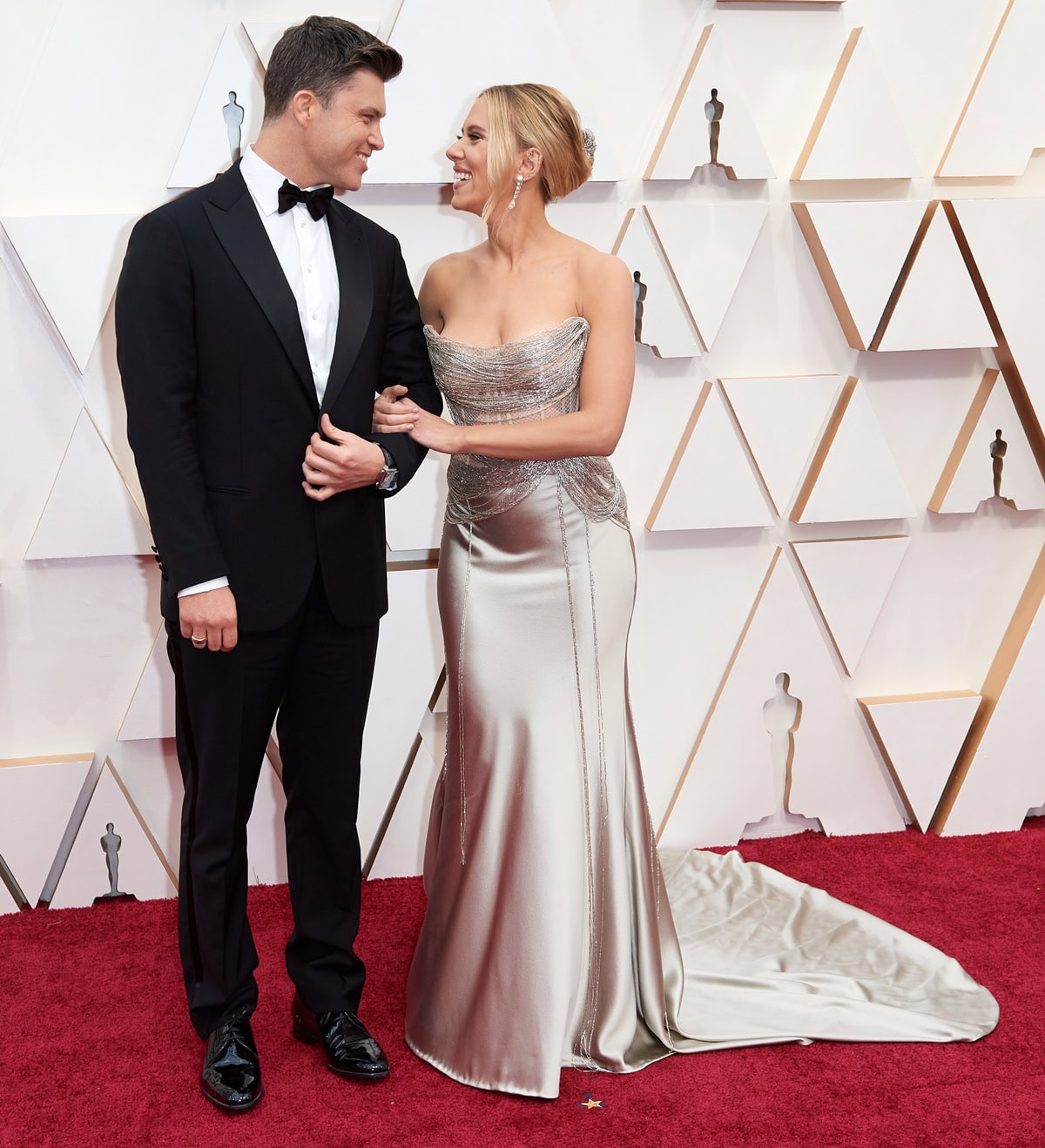 Scarlett Johansson dazzles in a metallic Oscar de la Renta gown with Jimmy Choo heels and Forevermark by Anita Ko jewels as she walks the 2020 Oscars red carpet alongside fiancé Colin Jost in Giorgio Armani