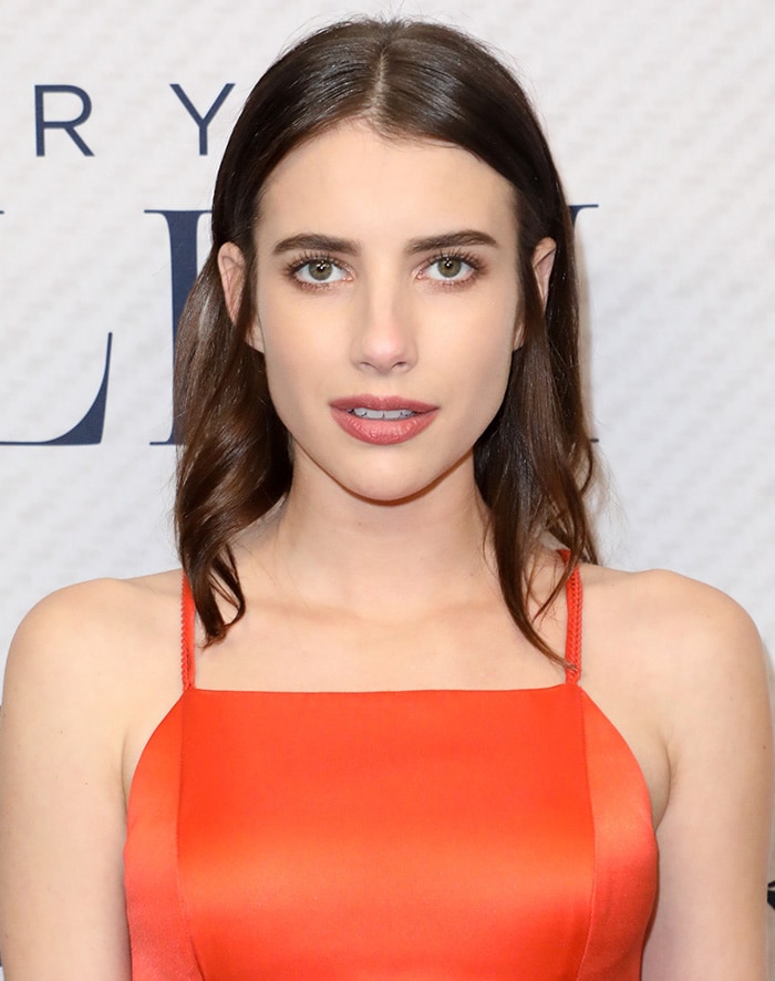Emma Roberts wears her shoulder-length brunette hair down and tucked behind her ears