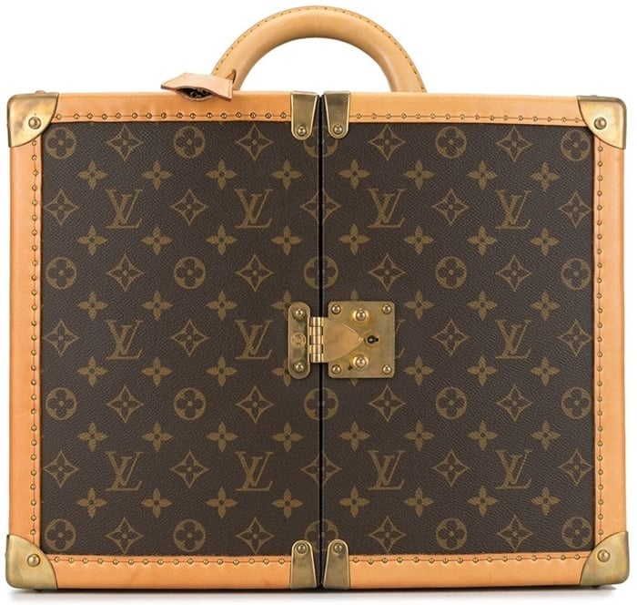 This brown leather trunk case from Louis Vuitton features a round top handle, a push-lock fastening, an all-over logo print, gold-tone hardware, a hanging key fob, an internal mirror, internal drawers, two removable logo-print bags, and two detachable shoulder straps