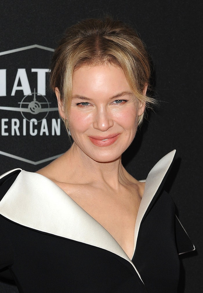 Renée Zellweger styles her blonde hair in a chic updo and wears soft pink makeup