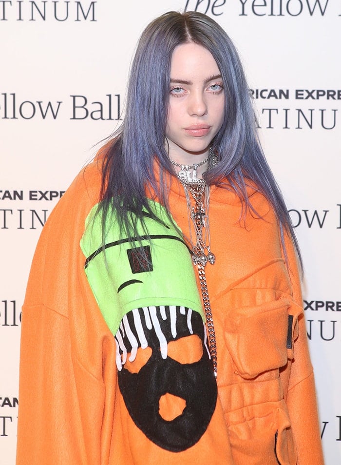 Billie Eilish in an orange hoodie at Pharrell Williams' Yellow Ball event on September 10, 2018