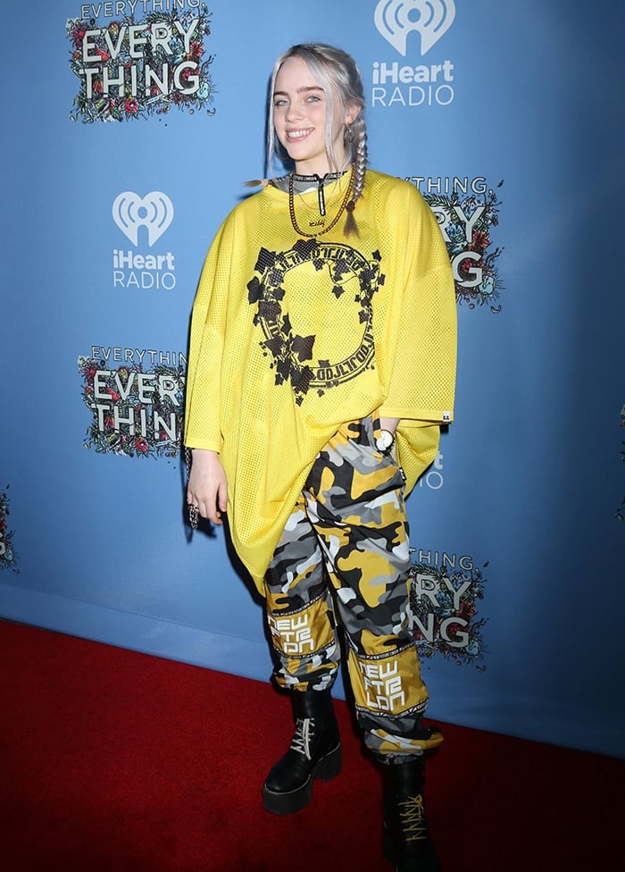 Billie Eilish in an oversized yellow jersey top and camo pants at Everything, Everything Los Angeles premiere on May 7, 2017