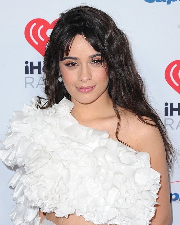 Camila Cabello wears her signature long curls with metallic eyeshadow and pink pout